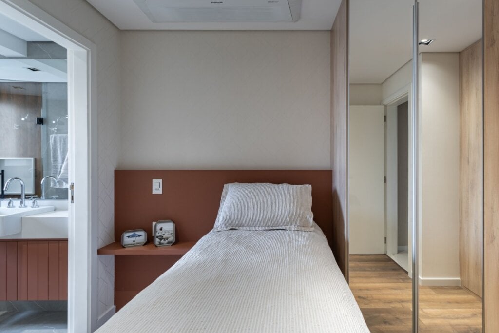 No quarto, o painel pode substituir a cabeceira, incorporar prateleiras e otimizar a circulação com estilo (Projeto: Camila Palladino | Imagem: David Aranha)