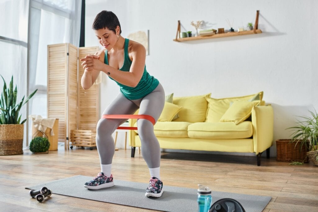 Elásticos e halteres ampliam a variedade e a intensidade do treino em casa, tornando os exercícios mais completos mesmo sem estrutura de academia (Imagem: LightField Studios | Shutterstock)