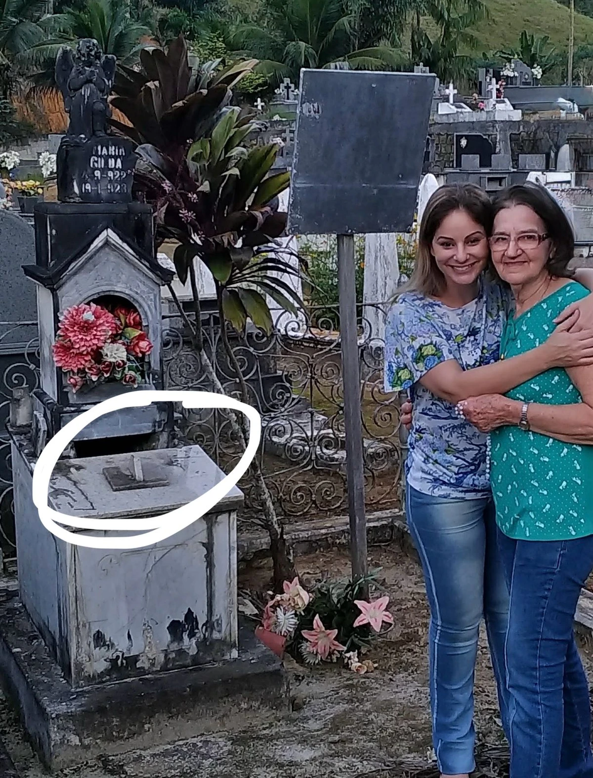 A comentarista Giovana Duarte próximo ao túmulo de Maria Gilda, que enche de água há mais de 90 anos, em cemitério municipal de Santa Leopoldina